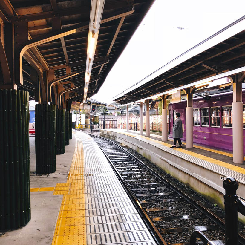 A man waiting on a train in the Arashiyama Train Station in Kyoto, Japan.