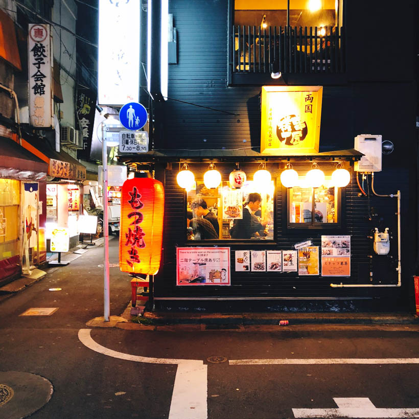 An Izakaya filled up with business men as seen from outside, in Ryogoku, Japan.