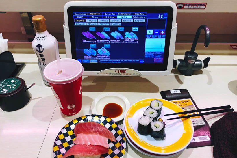 A plate of conveyor belt sushi at a Genki chain restaurant in Shibuya, Japan, with a touch screen that is used to order food, drinks and snacks.